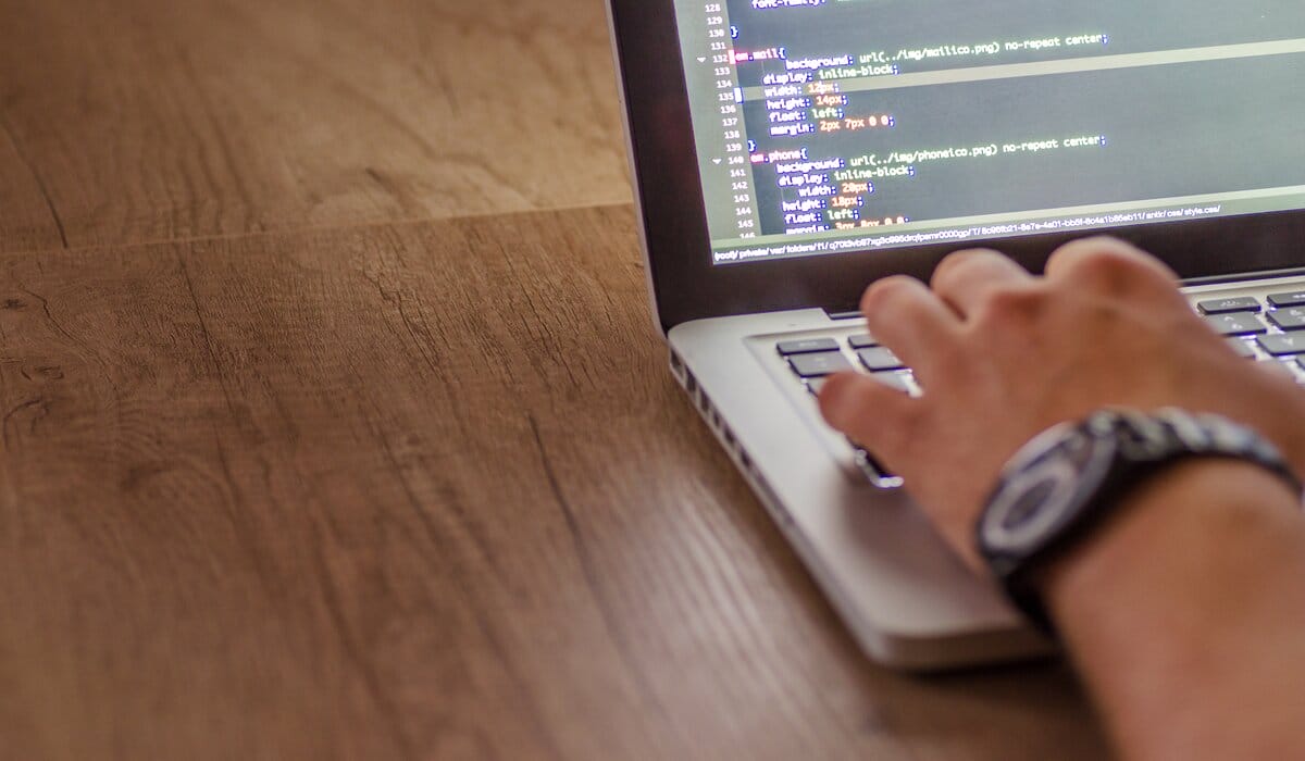 Person Typing On Laptop Showing Code Text