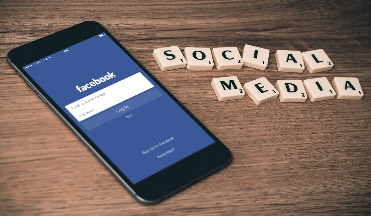 Smartphone Showing Facebook Application And Scrabble Blocks Spelling Out Social Media