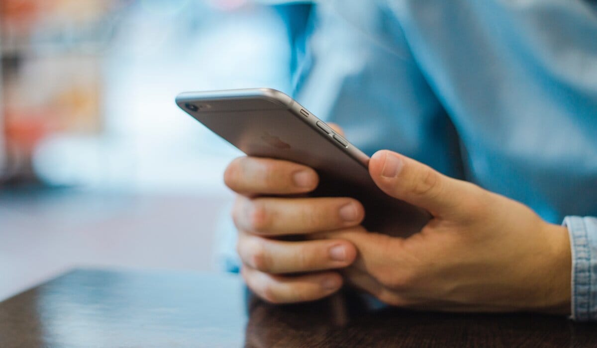 Person In Blue Clothes Holding An Iphone
