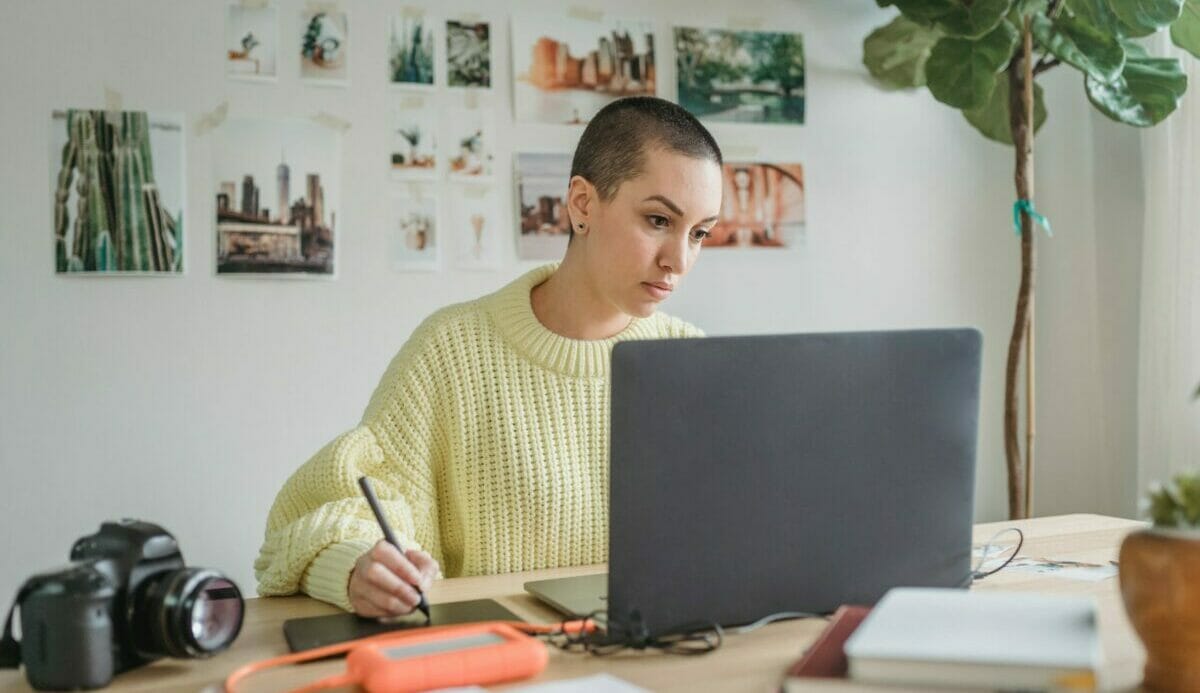 Serious Woman Working On Laptop And Using Drawing Tablet