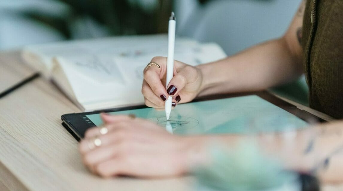 Anonymous Female Designer Using Tablet For Drawing